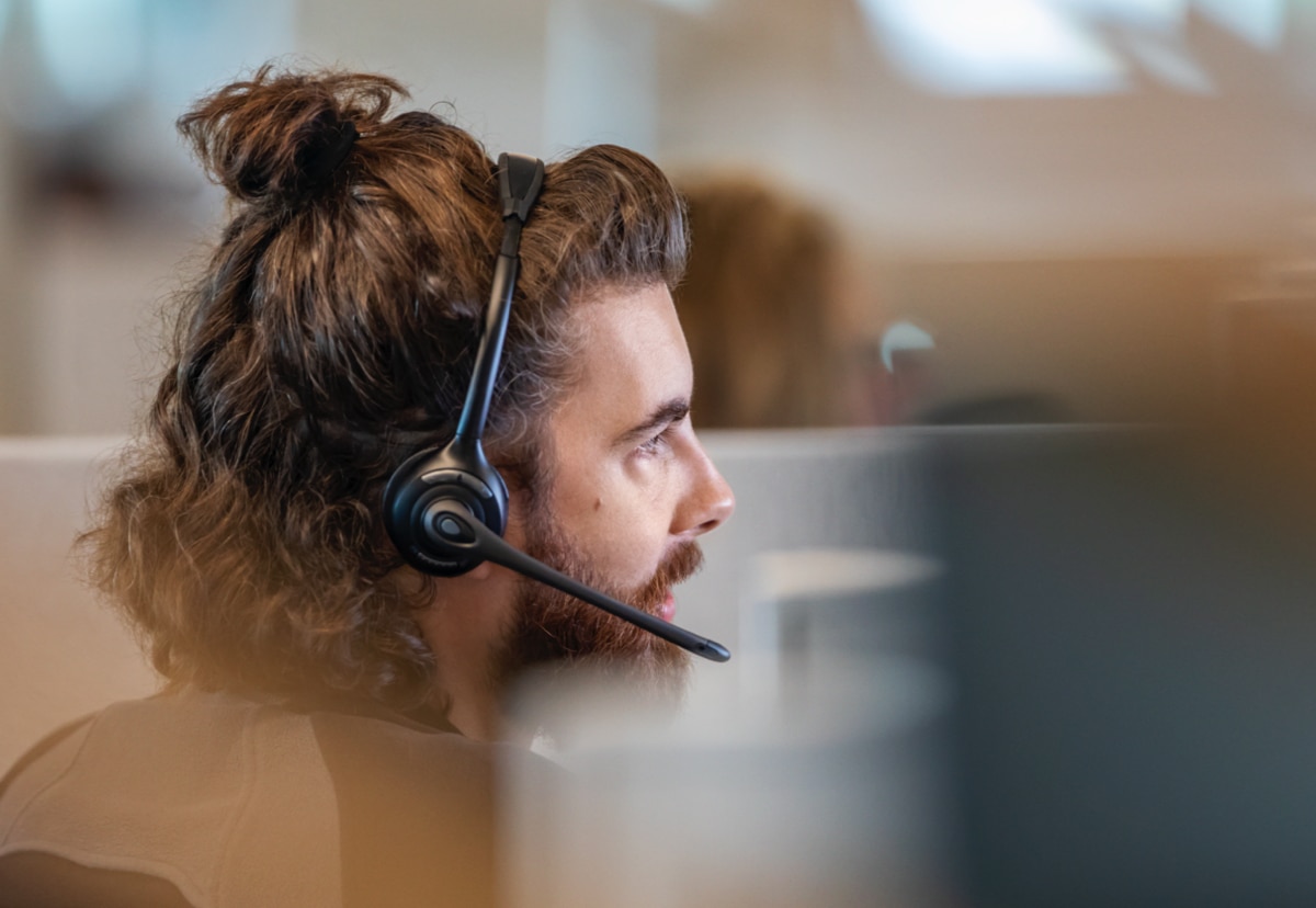 A person uses a headset to speak to someone on the phone.