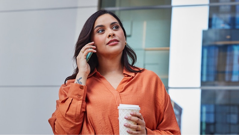 A woman taking a phone call outside her office building.