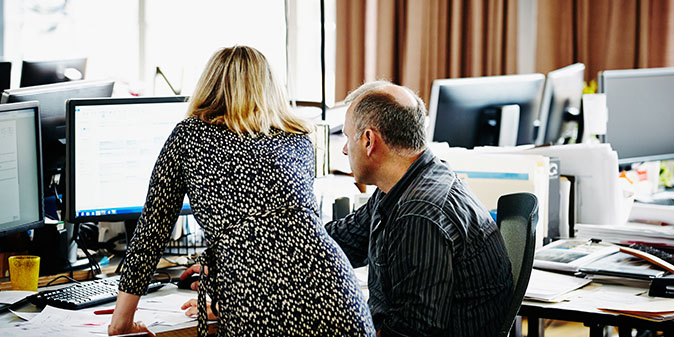 2 workers at a computer