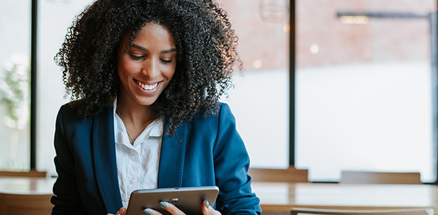 Person looking down at a tablet and smiling.