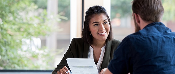 Two people sitting at a table reviewing documents.