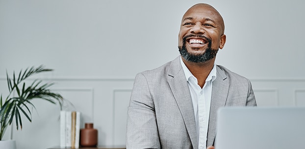 Person looking up from their laptop and smiling.