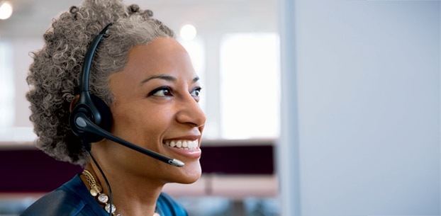 Customer service representative wearing a headset and smiling.